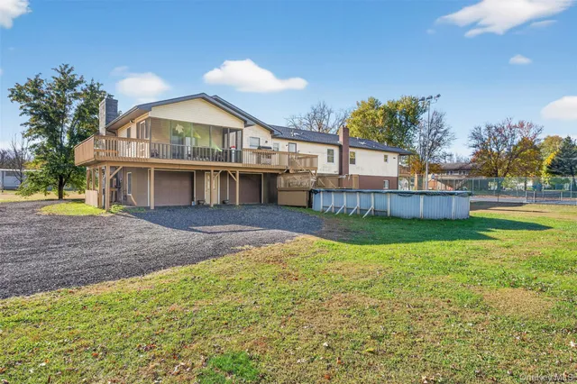 a view of house with backyard and tree