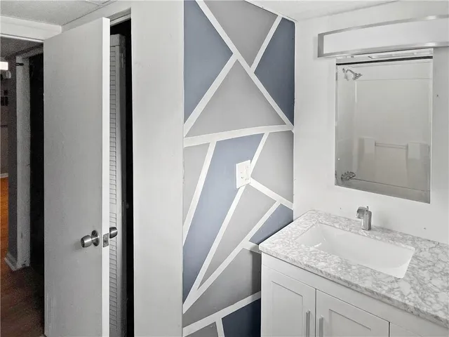 a bathroom with a granite countertop sink and a mirror
