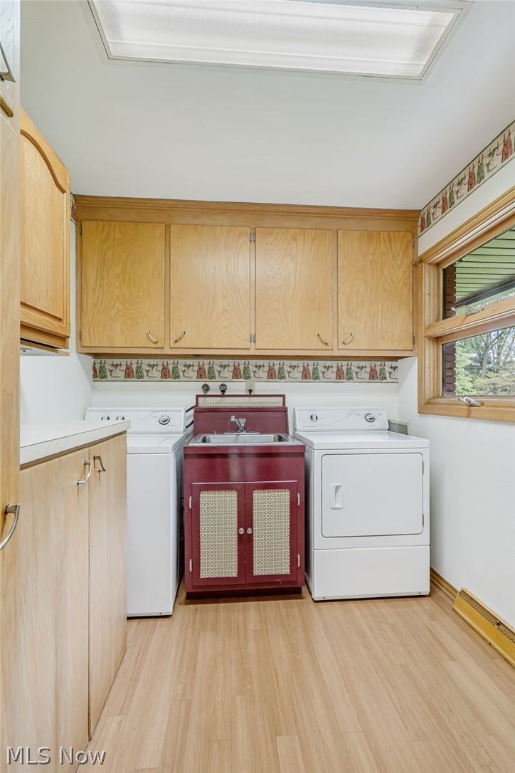1010 Knollwood Road Northwest Canton, OH 44708 - Photo 20 of 47 Laundry room featuring washer and dryer, cabinets, sink, and light wood-type flooring