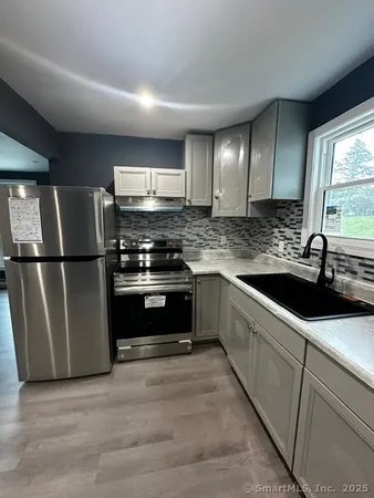 a kitchen with stainless steel appliances granite countertop a sink stove and refrigerator