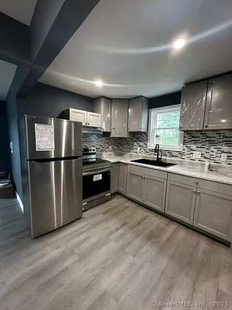 a kitchen with stainless steel appliances granite countertop a refrigerator sink and cabinets
