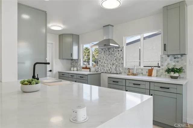 a kitchen with stainless steel appliances a sink a stove and white cabinets