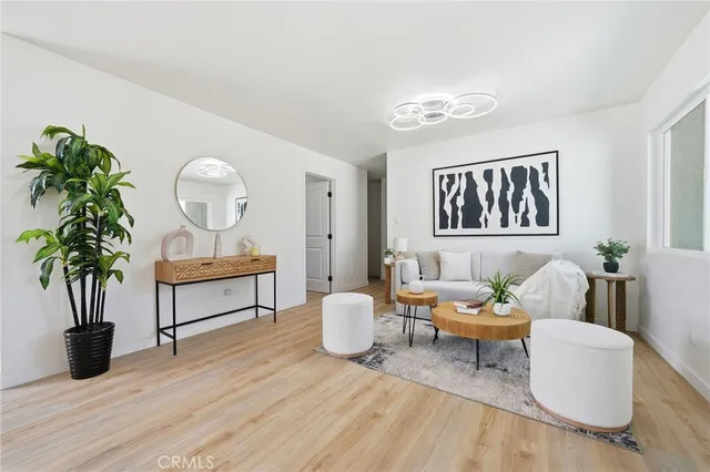 a living room with furniture potted plant and wooden floor
