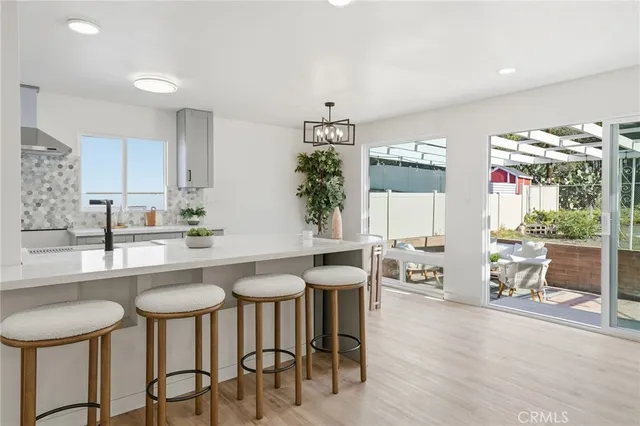 a kitchen with stainless steel appliances granite countertop a table and chairs in it