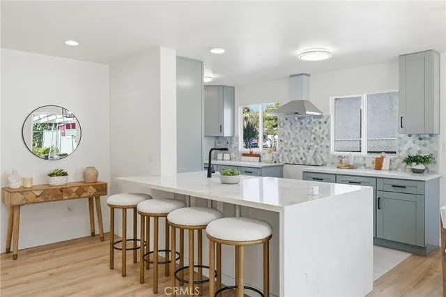 a dining hall with stainless steel appliances kitchen island a table and chairs in it