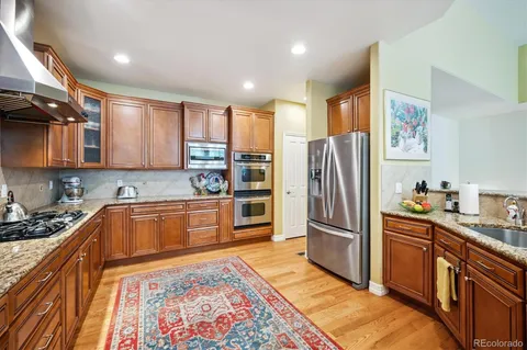 a kitchen with stainless steel appliances granite countertop a refrigerator a stove a sink and a microwave