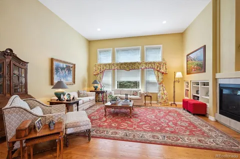 a living room with furniture and a dining table with wooden floor