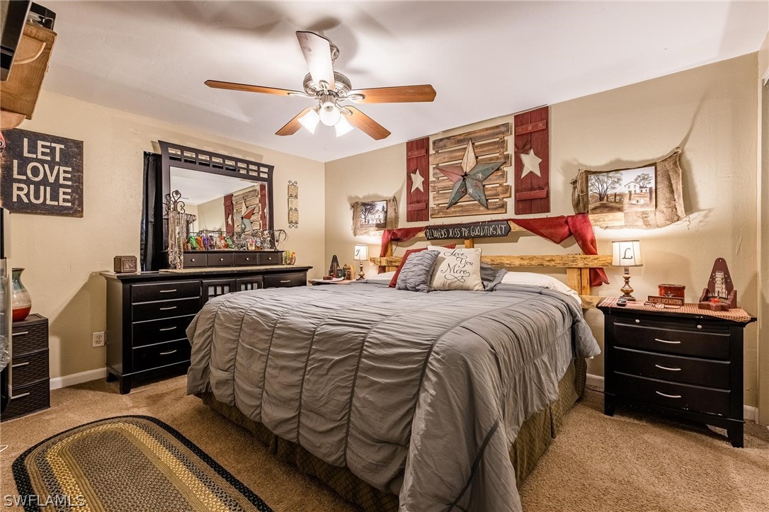2313 Hamilton Avenue Alva, FL 33920 - Photo 21 of 30 a bedroom with a bed and dresser with mirror