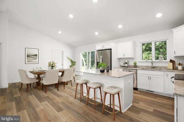 a view of a dining room with furniture a rug and wooden floor