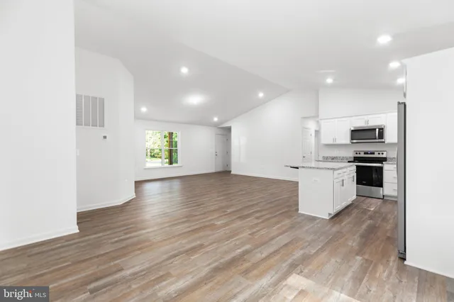 a view of kitchen with stove and wooden floor