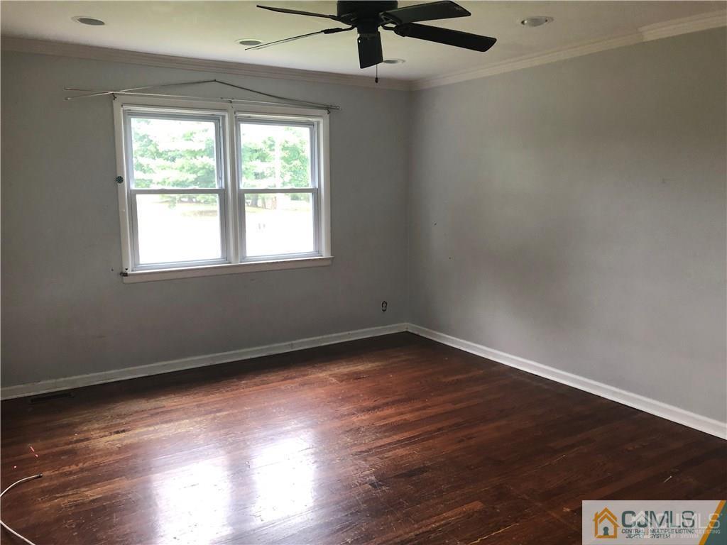 182 Prospect Plains Road Monroe Township, NJ 08831 - Photo 11 of 22 a view of an empty room with wooden floor and a window