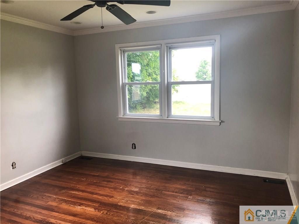 182 Prospect Plains Road Monroe Township, NJ 08831 - Photo 12 of 22 an empty room with wooden floor and windows