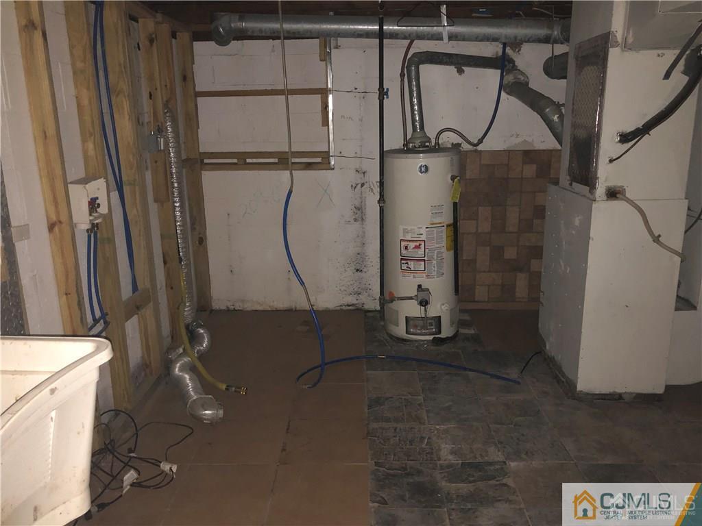 182 Prospect Plains Road Monroe Township, NJ 08831 - Photo 16 of 22 a room with water heater and a cabinet