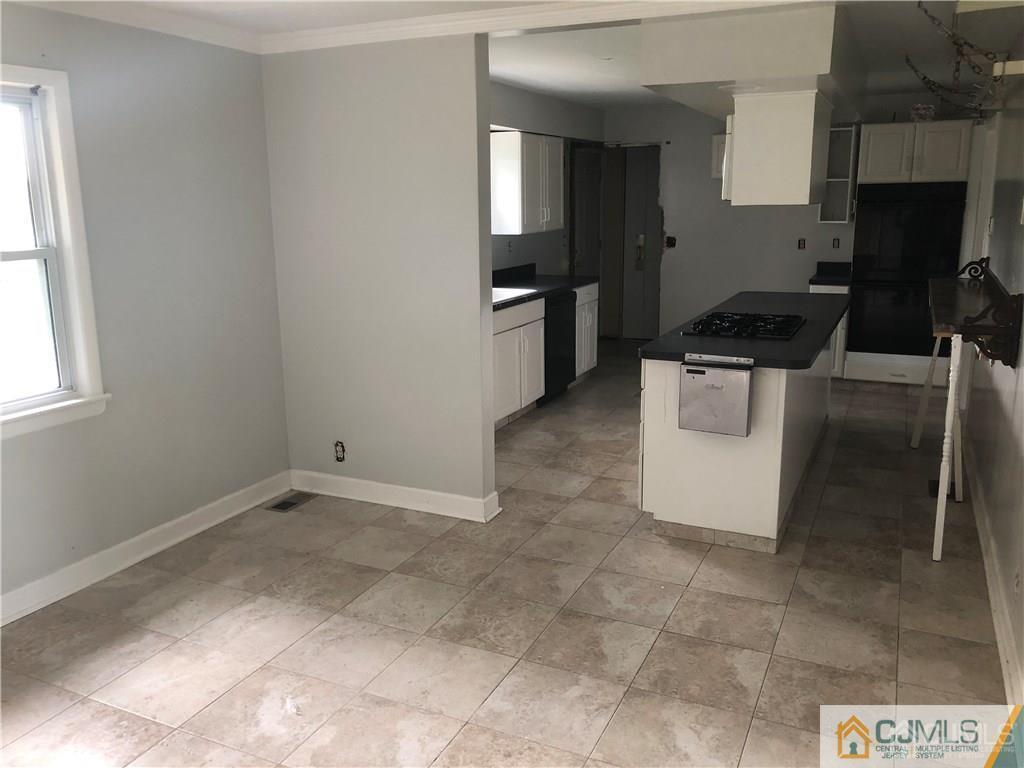 182 Prospect Plains Road Monroe Township, NJ 08831 - Photo 6 of 22 a kitchen with granite countertop a stove a sink and a microwave