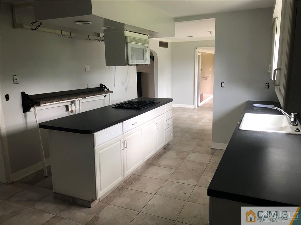 182 Prospect Plains Road Monroe Township, NJ 08831 - Photo 7 of 22 a kitchen with a sink and a stove