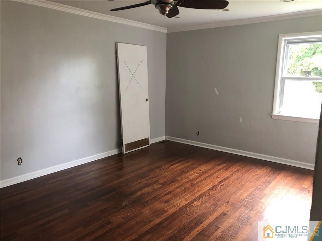 182 Prospect Plains Road Monroe Township, NJ 08831 - Photo 10 of 22 an empty room with wooden floor and windows