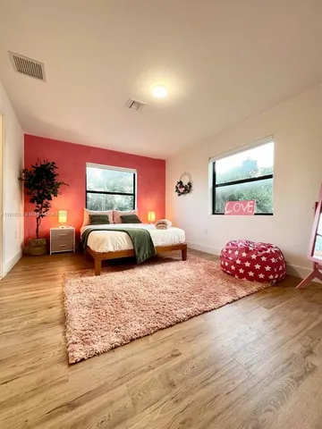 a bed sitting in a bedroom next to a window