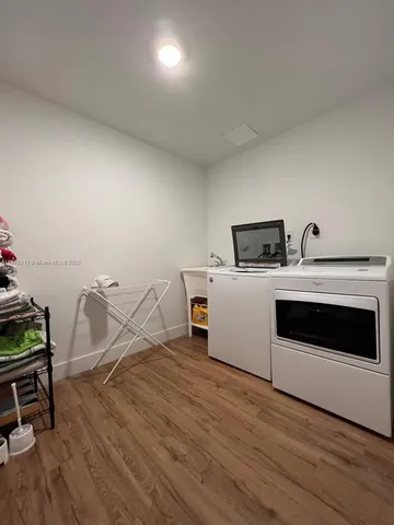 a view of a hallway with wooden floor and entryway