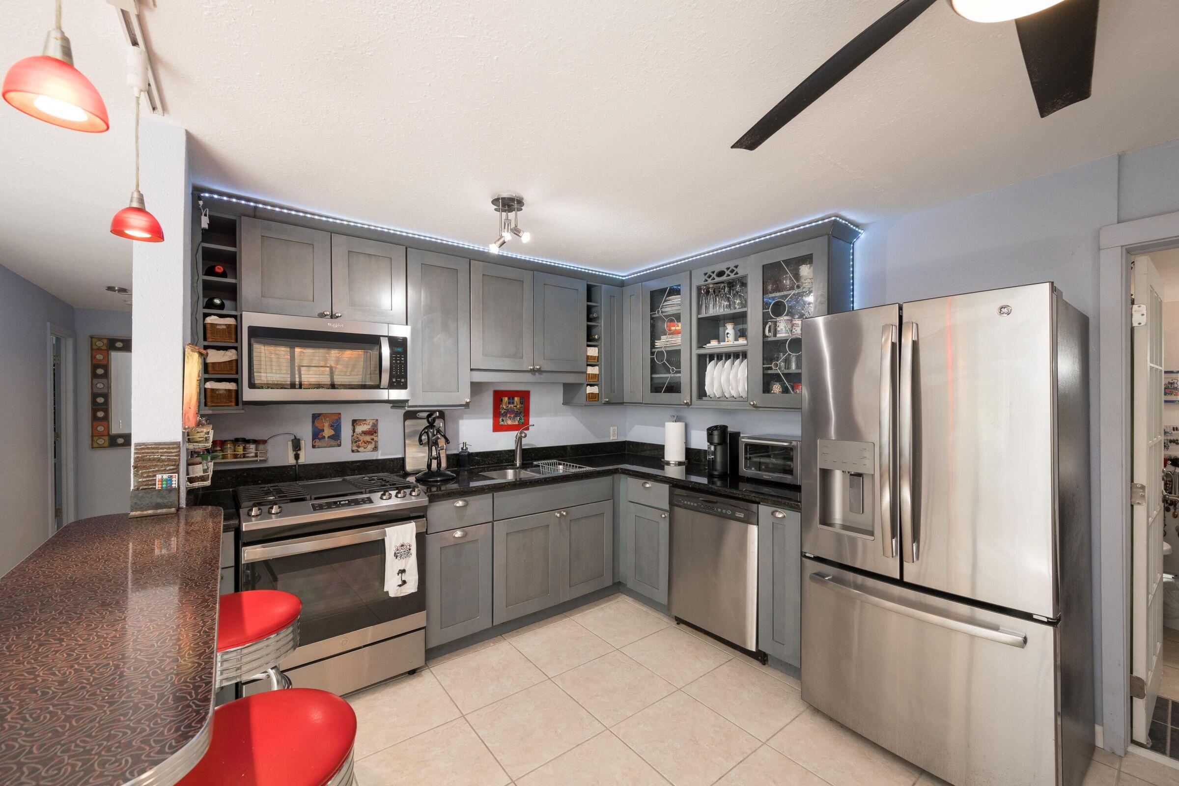 206 4th Street Key West, FL 33040 - Photo 27 of 44 a kitchen with stainless steel appliances granite countertop a refrigerator sink and stove