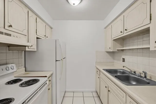 a kitchen with a refrigerator and a stove top oven