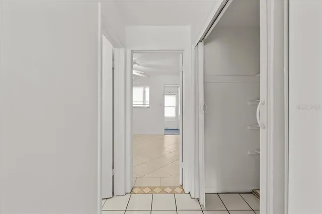 an empty room with white walls and ceiling fan