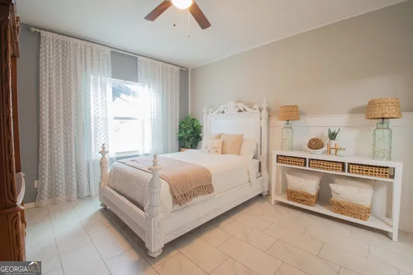 a bedroom with a bed and a chandelier fan