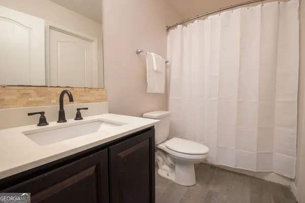 a bathroom with a sink a toilet and a mirror