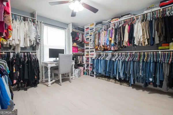 a view of walk in closet with clothes