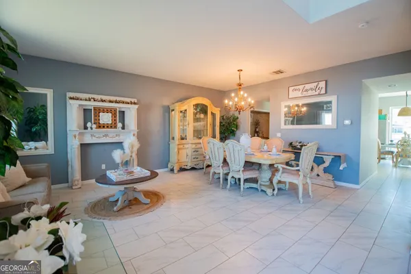 a living room with furniture a dining table and chairs with kitchen view