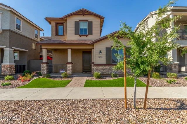 a front view of a house with a yard and potted plants