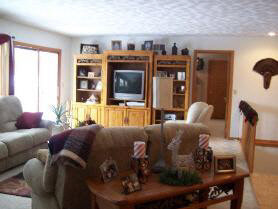 2791 Shopiere Road Beloit, WI 53511 - Photo 5 of 6 a living room with furniture a flat screen tv and a floor to ceiling window