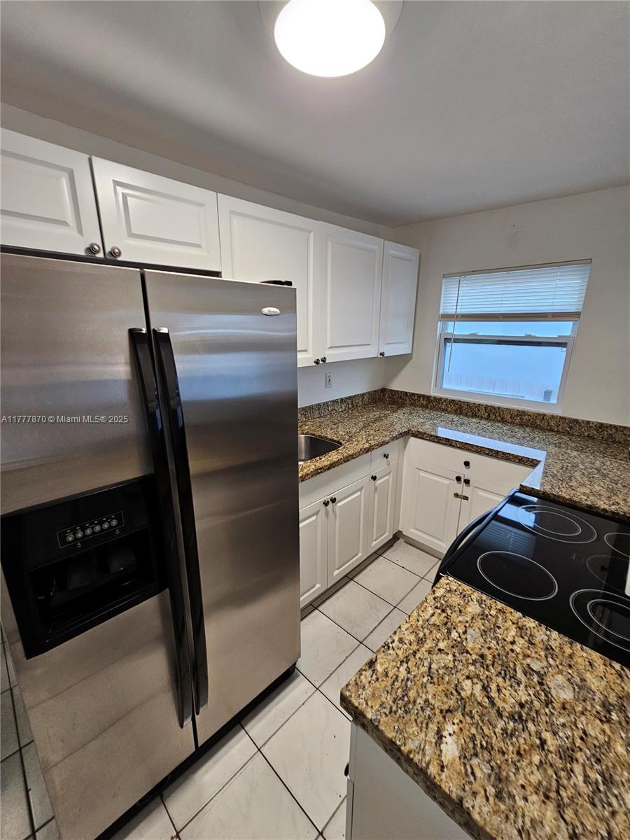 330 Southwest 79th Court, Unit 2 Miami, FL 33144 - Photo 4 of 9 a kitchen with a refrigerator stove and cabinets
