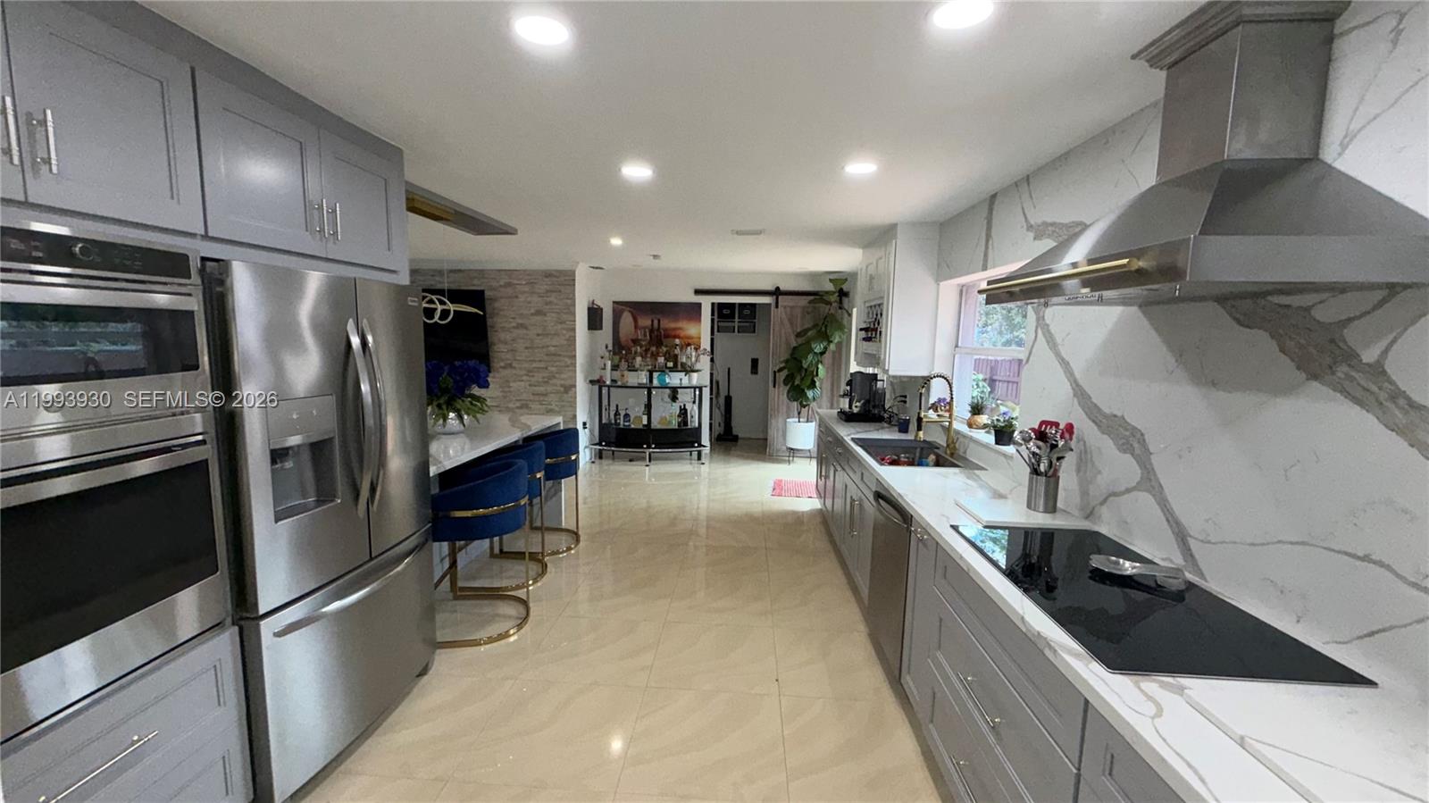 10550 Southwest 51st Street Cooper City, FL 33328 - Photo 15 of 37 a kitchen with stainless steel appliances a refrigerator a sink a stove and cabinets