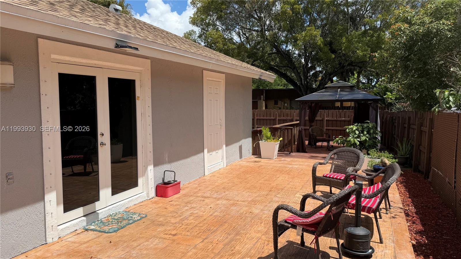 10550 Southwest 51st Street Cooper City, FL 33328 - Photo 33 of 37 a view of a patio with table and chairs potted plants and large tree