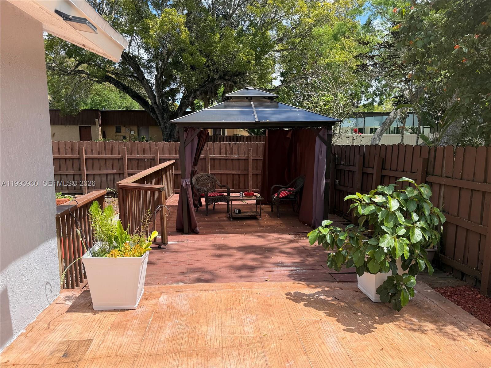 10550 Southwest 51st Street Cooper City, FL 33328 - Photo 34 of 37 a view of a chair and table in the patio next to a yard