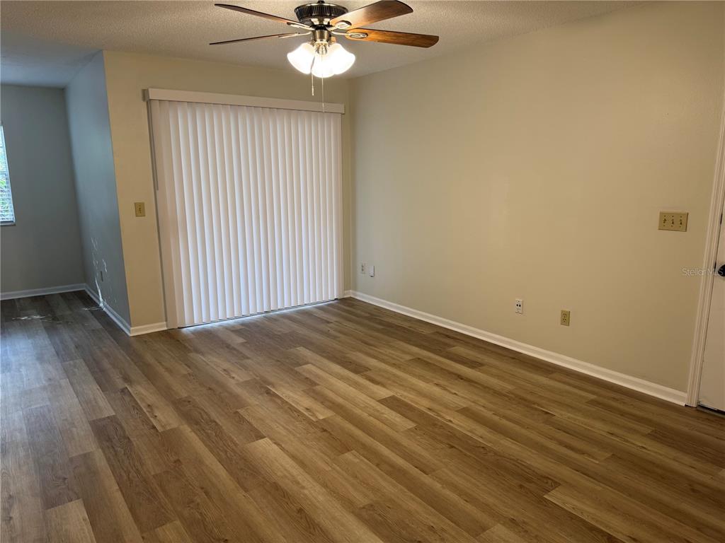 513 Green Spring Circle Winter Springs, FL 32708 - Photo 10 of 12 an empty room with wooden floor fan and windows