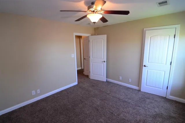 an empty room and chandelier fan