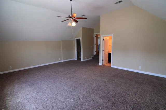 an empty room with chandelier fan