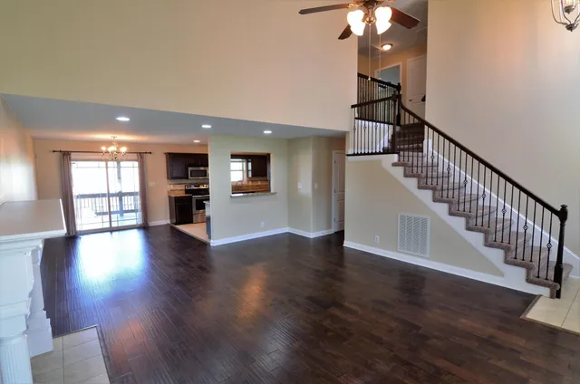 a view of a livingroom with wooden floor and stairs