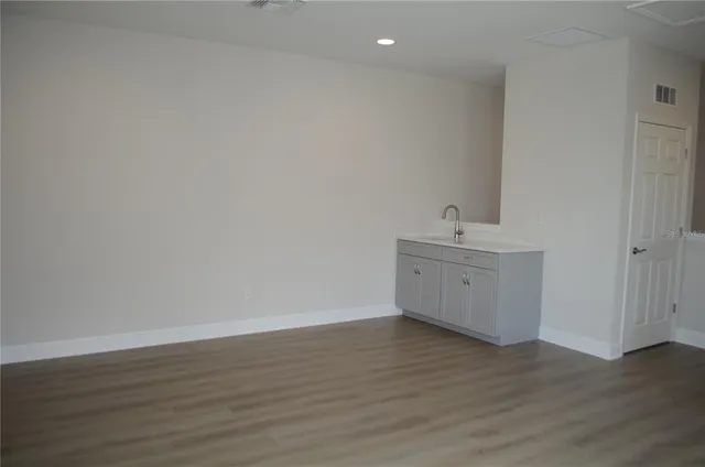 a view of a room with wooden floor and white walls