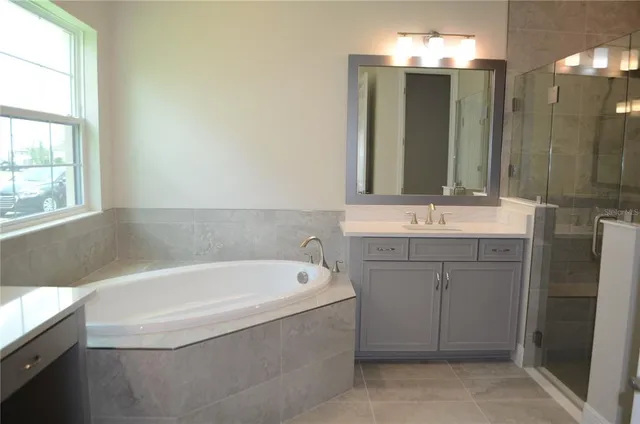 a bathroom with a tub sink and mirror