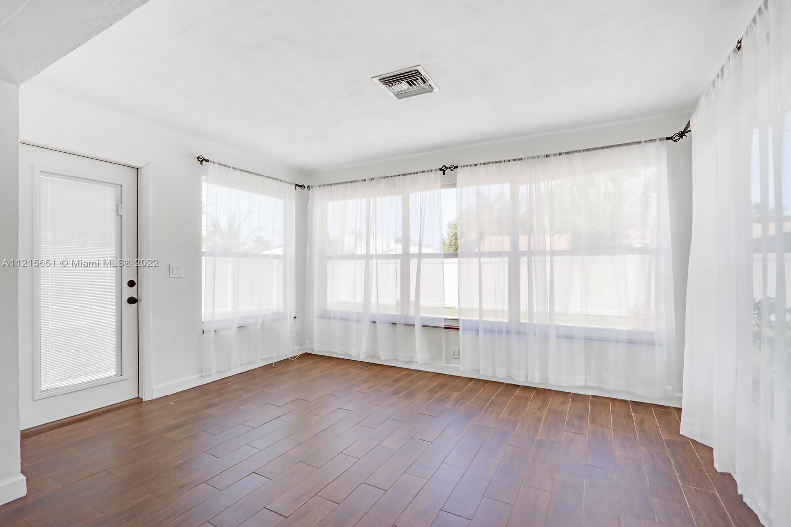 1515 Seabrook Road Jupiter, FL 33469 - Photo 13 of 29 an empty room with wooden floor and windows