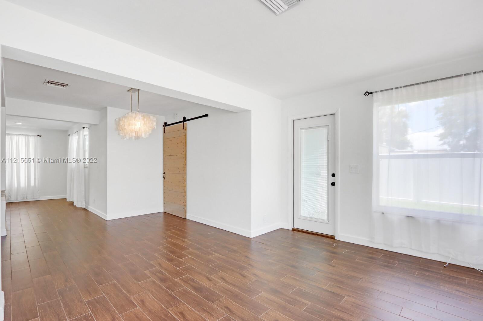1515 Seabrook Road Jupiter, FL 33469 - Photo 15 of 29 a view of an empty room with wooden floor and a window