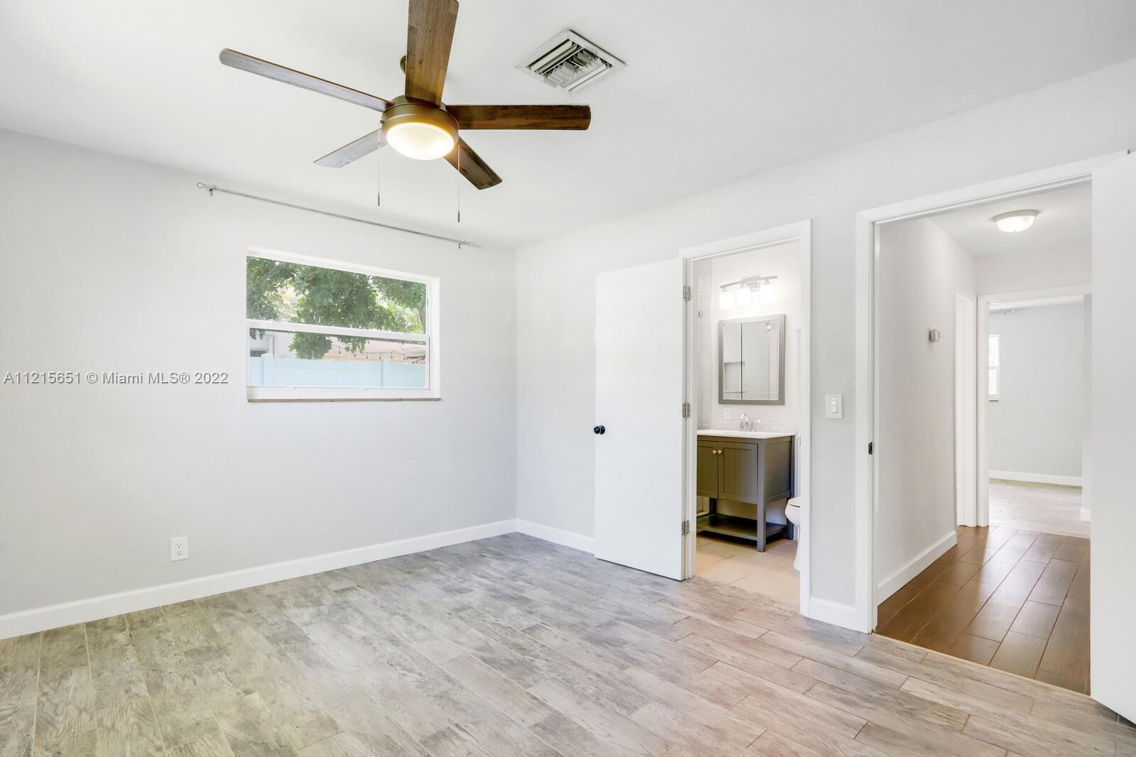 1515 Seabrook Road Jupiter, FL 33469 - Photo 20 of 29 a view of an empty room with wooden floor and a ceiling fan