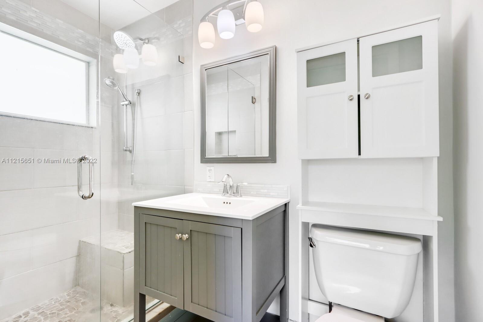 1515 Seabrook Road Jupiter, FL 33469 - Photo 21 of 29 a bathroom with a sink a toilet and mirror