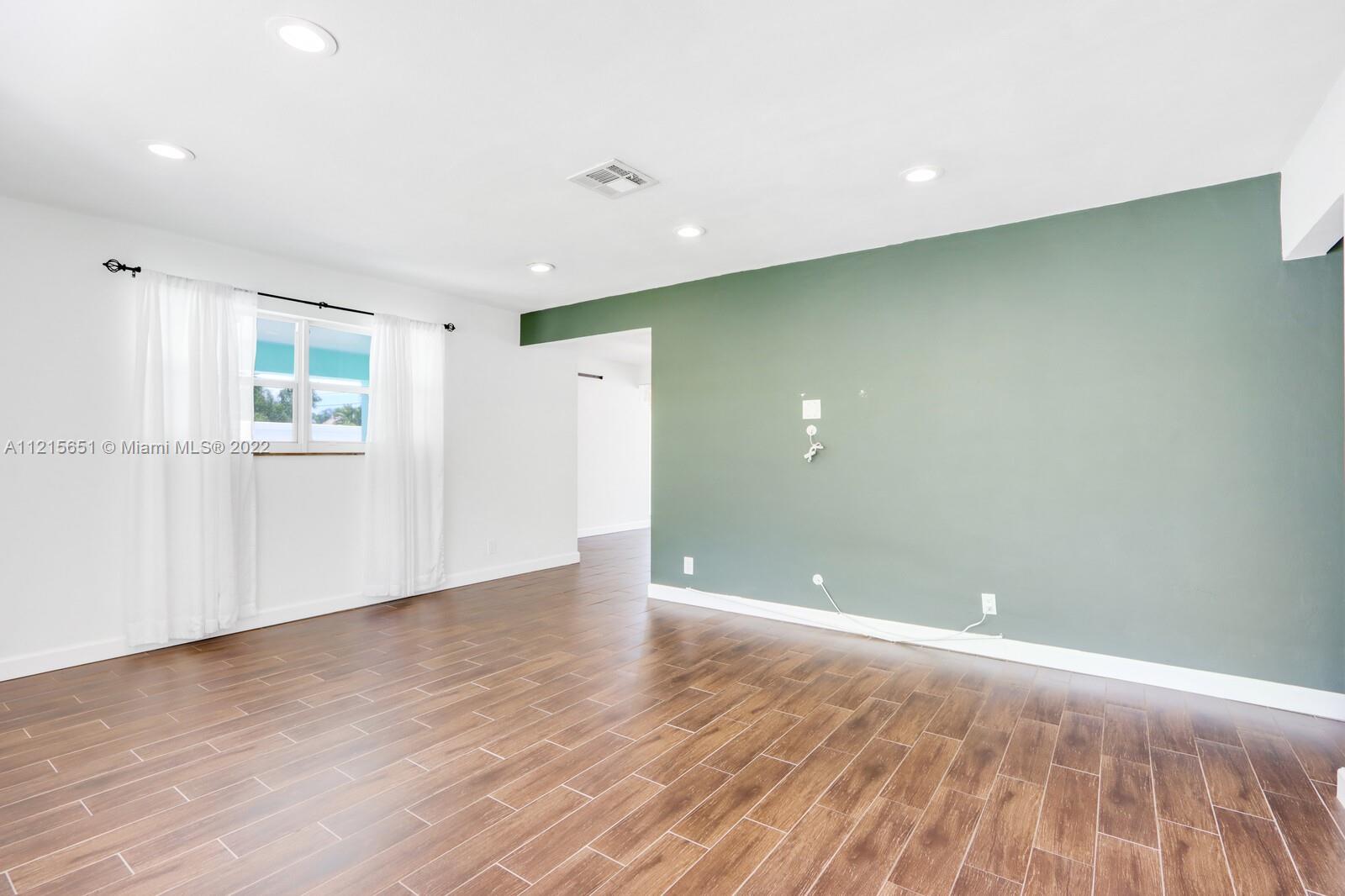 1515 Seabrook Road Jupiter, FL 33469 - Photo 4 of 29 wooden floor in an empty room with a window