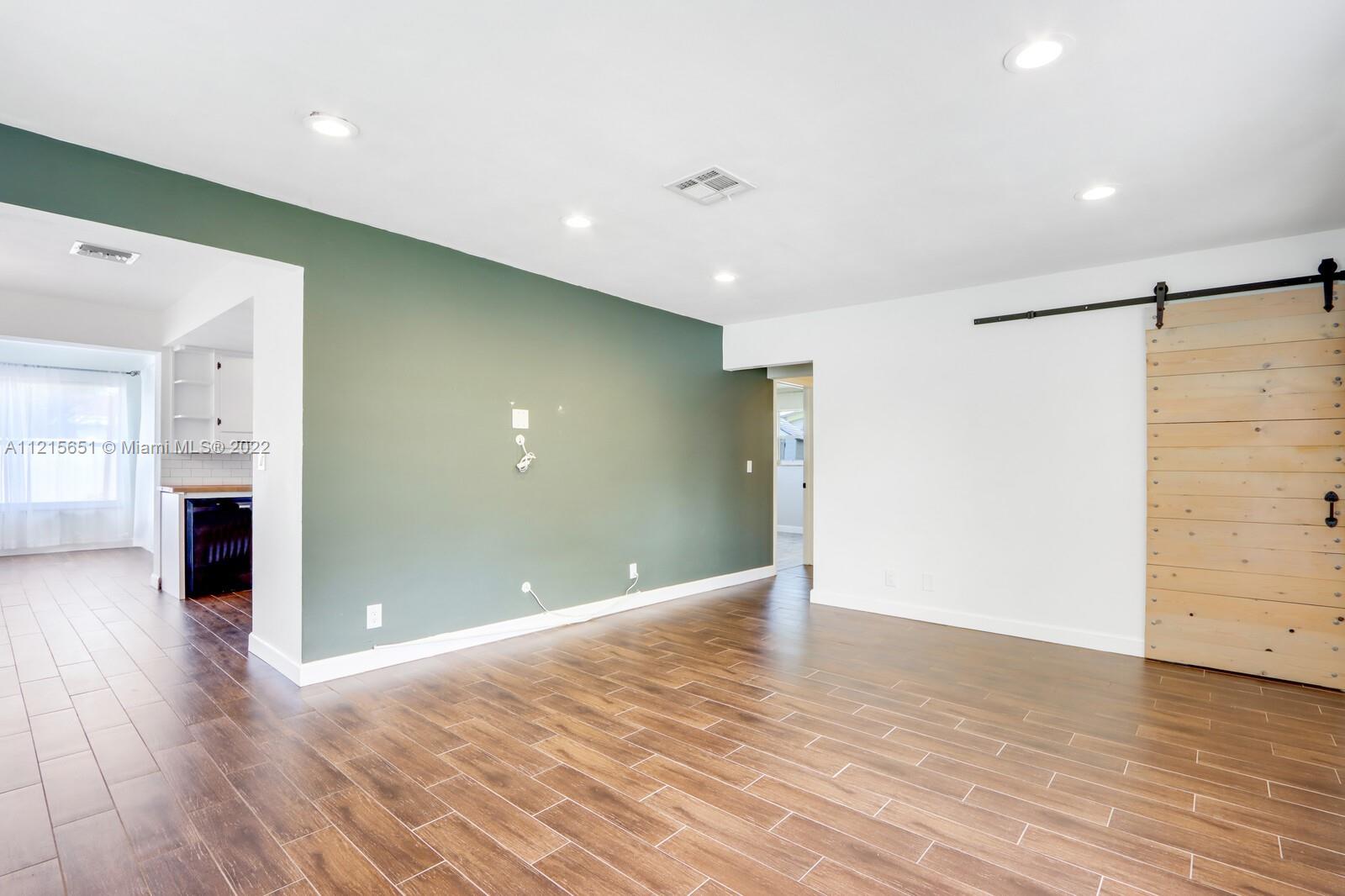 1515 Seabrook Road Jupiter, FL 33469 - Photo 5 of 29 an empty room with wooden floor and windows
