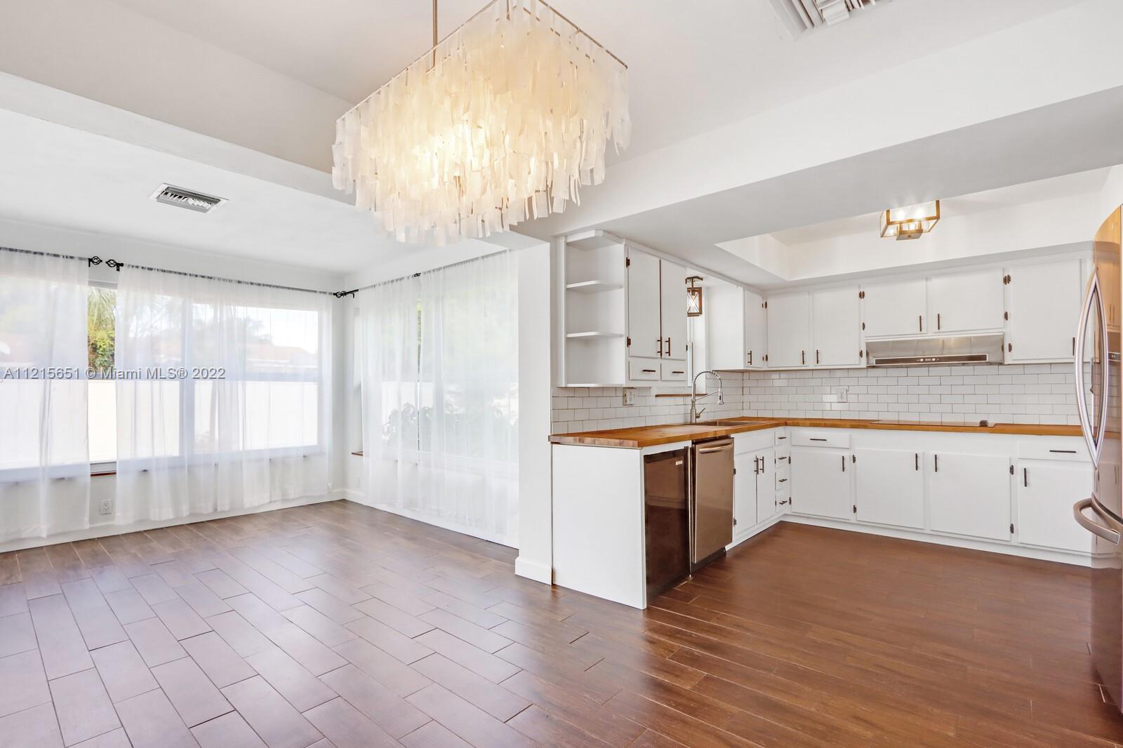 1515 Seabrook Road Jupiter, FL 33469 - Photo 7 of 29 a large kitchen with cabinets wooden floor and stainless steel appliances