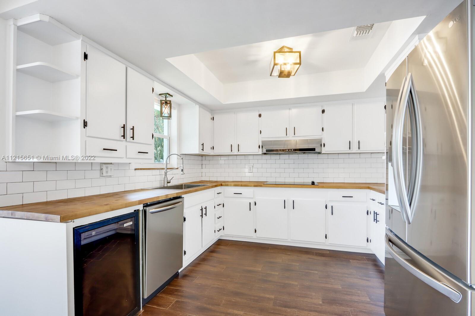 1515 Seabrook Road Jupiter, FL 33469 - Photo 8 of 29 a kitchen with granite countertop white cabinets white stainless steel appliances and a sink