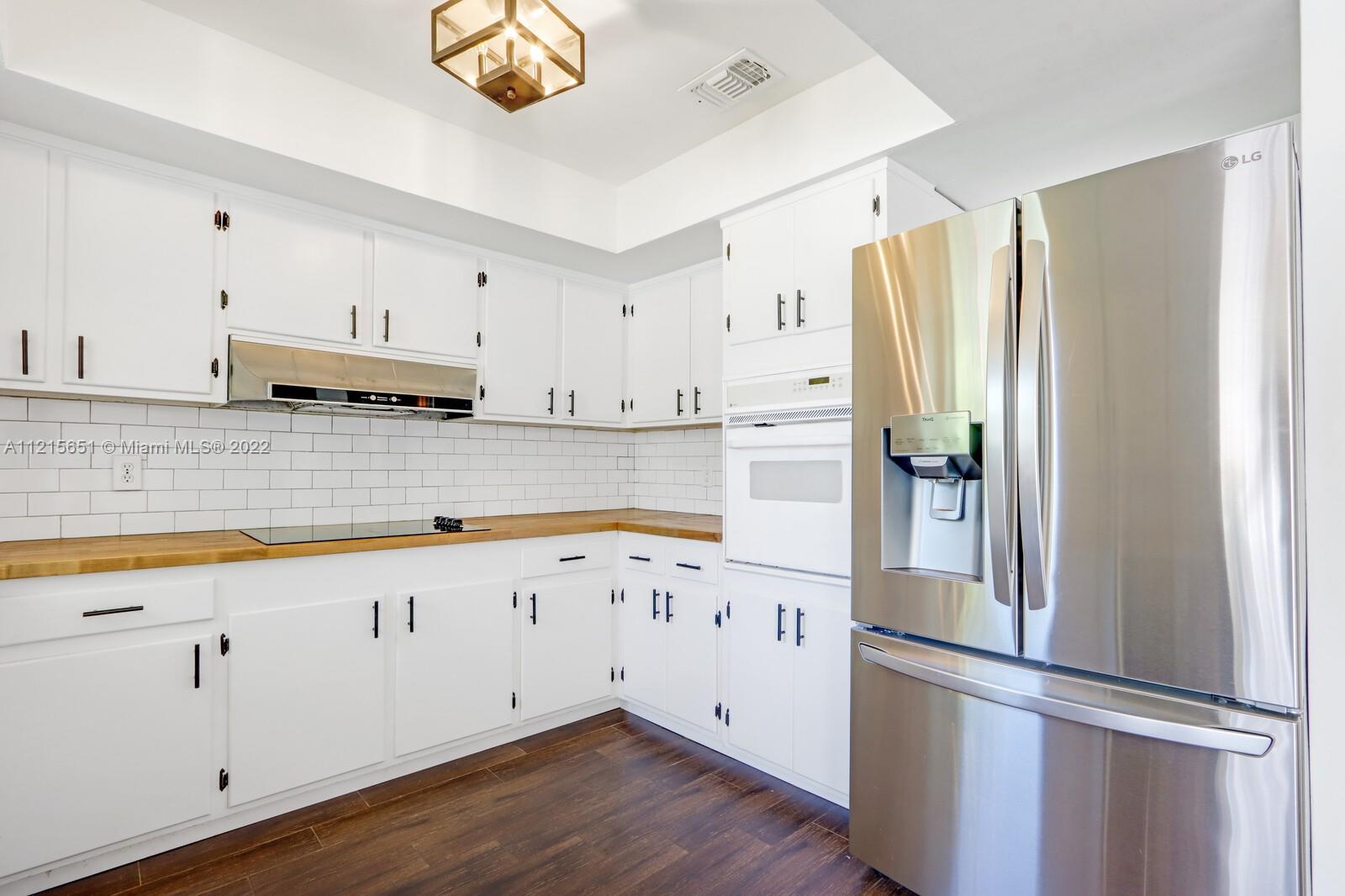 1515 Seabrook Road Jupiter, FL 33469 - Photo 9 of 29 a kitchen with cabinets a refrigerator and a sink